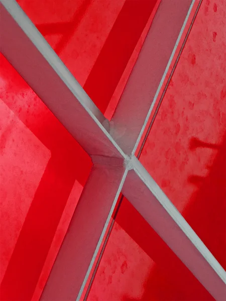 Srebrna metalowa konstrukcja pokryta czerwonym materiałem, połączenia. — Zdjęcie stockowe