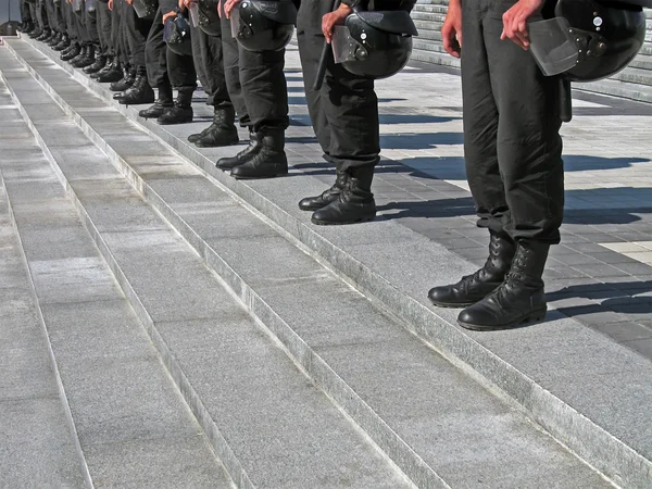 Police cordon in black uniform with hard hat (helmet), security. — Stock Photo, Image