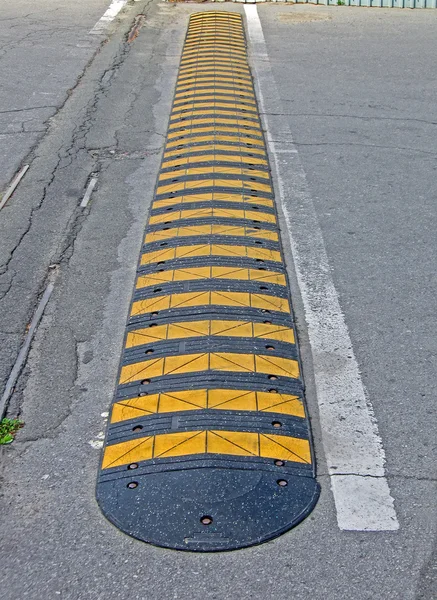 Abstracte gele gestripte weg barrière voor auto's op asfalt, veiligheid. — Stockfoto