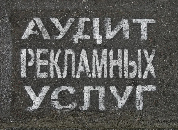Reclame service audit als geschilderde tekst op Russisch op asfalt. — Stockfoto