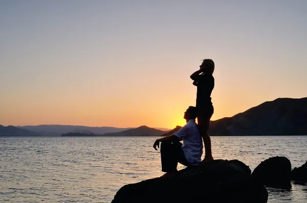 Jovem casal admirando o pôr do sol — Fotografia de Stock