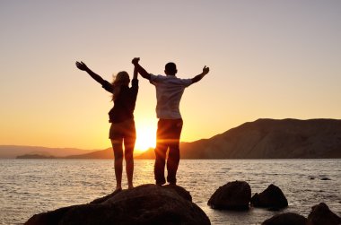 Young couple raised their hands to the sky clipart