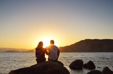 Loving couple looking at the sun clipart