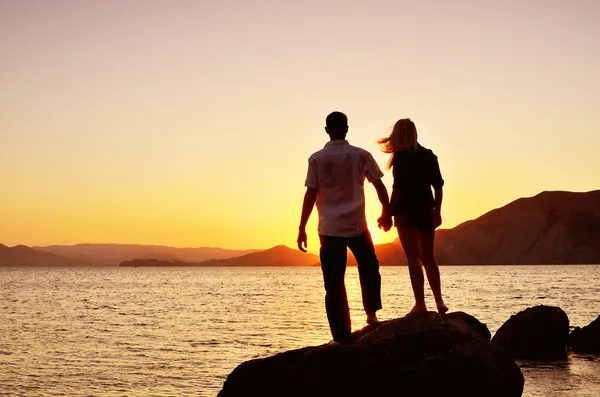 Paar beobachtet die Sonne am Meer — Stockfoto