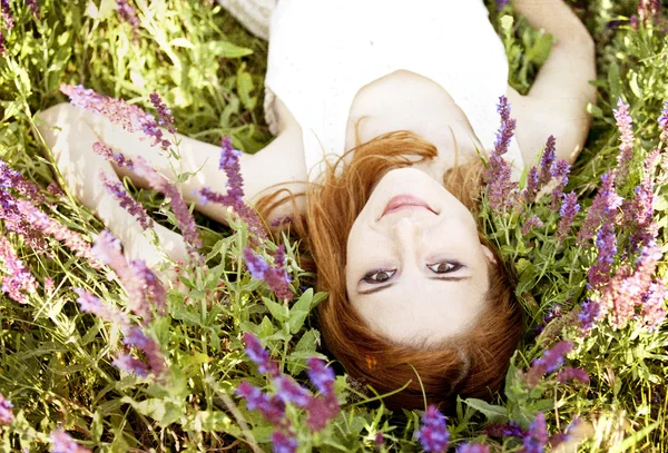 Jonge mode meisje liggen op groen gras. — Stockfoto