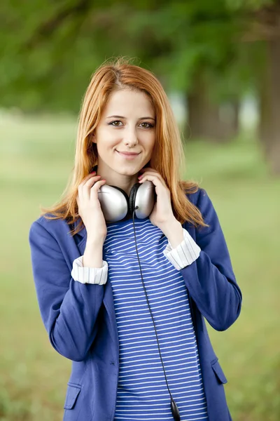 Jeune fille de la mode avec écouteurs au printemps en plein air . — Photo