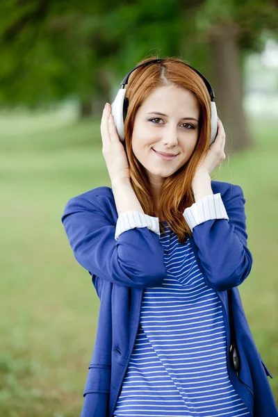 Chica de moda joven con auriculares en primavera al aire libre . —  Fotos de Stock