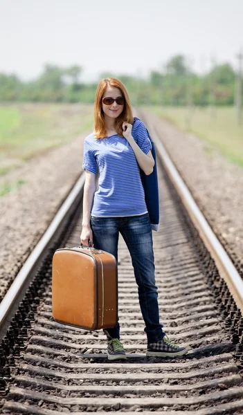 在铁路的手提箱的年轻时尚女孩. — 图库照片
