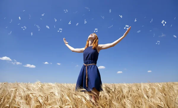 Rusovláska dívka v pšeničné pole v letním dni s abstraktní poznámkami. — Stock fotografie