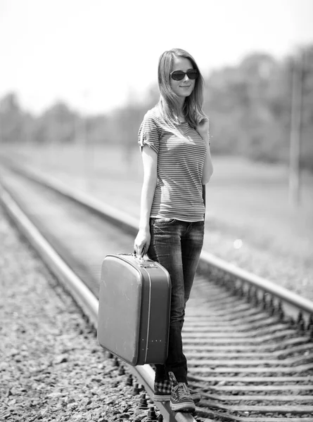 Junges Modemädchen mit Koffer bei der Bahn. — Stockfoto