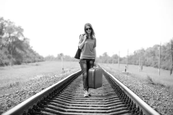 Junges Modemädchen mit Koffer bei der Bahn. — Stockfoto