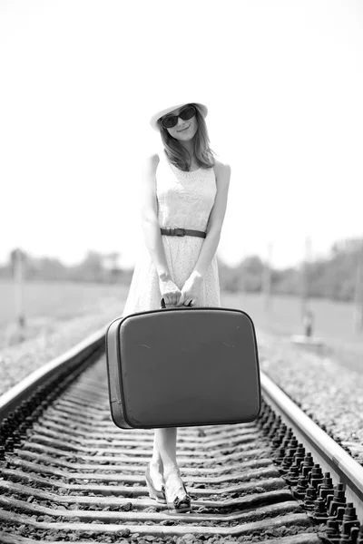 Молодая девушка моды с чемоданом на железной дороге . — стоковое фото