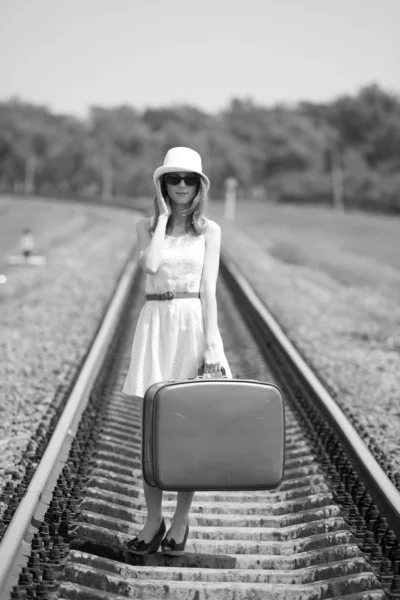 Young fashion girl with suitcase at railways. Royalty Free Stock Images