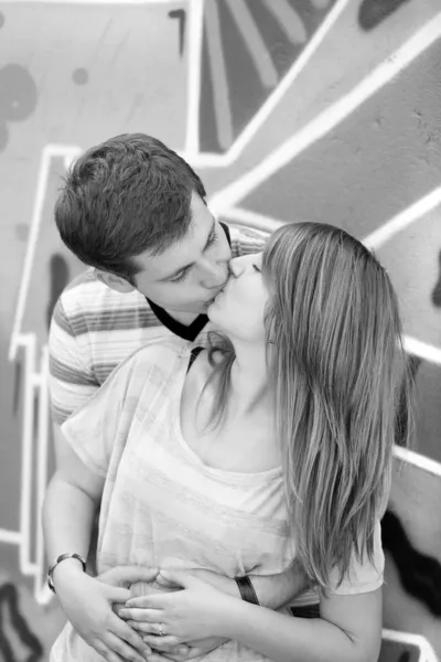 Giovane coppia baciare vicino graffiti sfondo . — Foto Stock