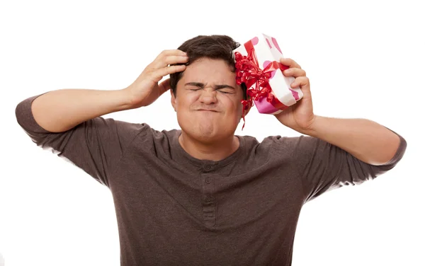 Сердитий чоловік тримає подарункову коробку на білому тлі . — стокове фото