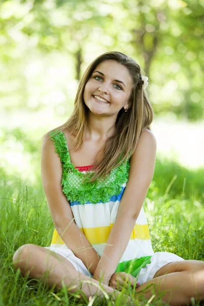 Schöne Teen-Mädchen im Park bei grünem Gras. — Stockfoto