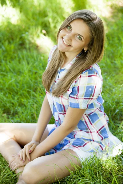 Hermosa chica adolescente en el parque en la hierba verde . — Foto de Stock