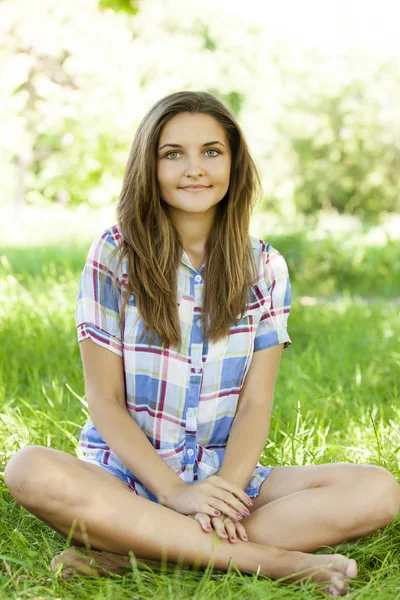 Menina adolescente bonita no parque em grama verde . — Fotografia de Stock