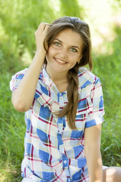 Piękna dziewczyna w parku na zielonej trawie. — Zdjęcie stockowe