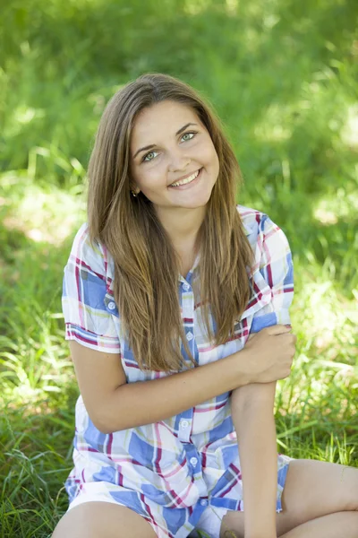 Menina adolescente bonita no parque em grama verde . — Fotografia de Stock