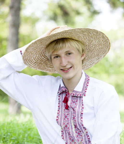 Молодой славянин на зеленом лугу в национальной одежде . — стоковое фото
