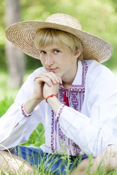 Jonge Slavische tiener op groene weide in nationale kleding. — Stockfoto