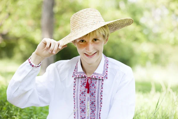 Νεαρός έφηβος Σλαβικών στο πράσινο λιβάδι στην εθνική ενδυμασία. — Φωτογραφία Αρχείου