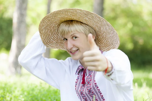 Junger slawischer Teenager in Nationalkleidung auf der grünen Wiese. — Stockfoto