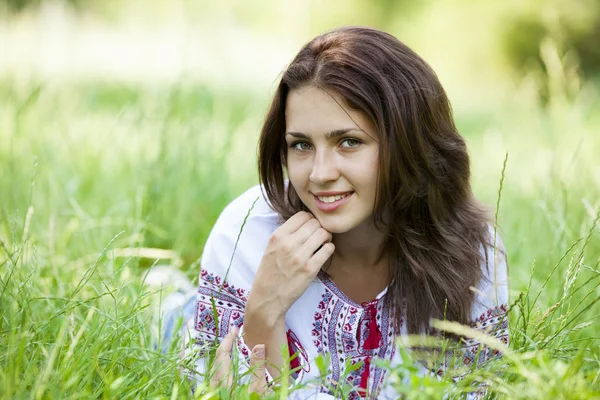 Slav dospívající dívka na zelené louce v národním ukrajinských oblečení. — Stock fotografie
