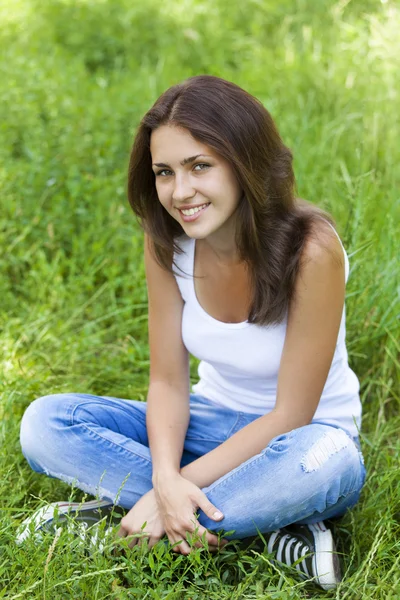 Beautiful teen girl in the park at green grass. Stock Image