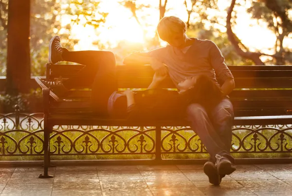 Молодая пара на скамейке на улице . — стоковое фото