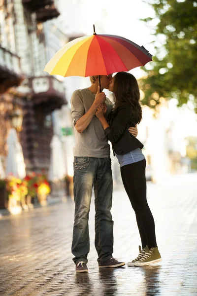 Νεαρό ζευγάρι στο δρόμο της πόλης με ομπρέλα — Φωτογραφία Αρχείου