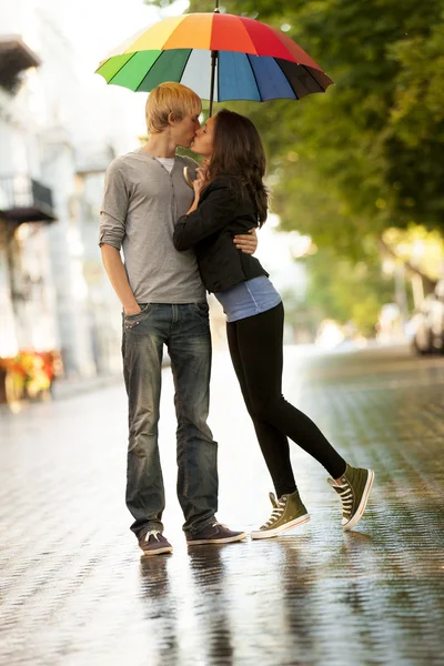 A fiatal pár, az utcán a város esernyő — Stock Fotó