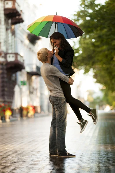 Coppia giovane sulla strada della città con ombrellone — Foto Stock