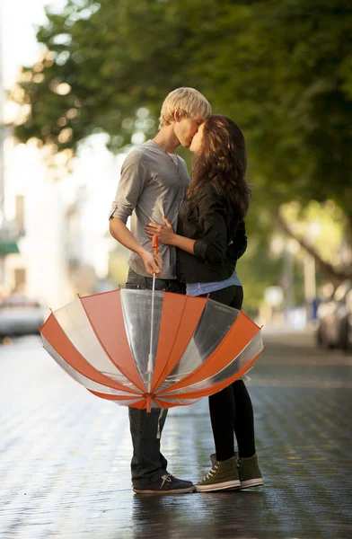 Νεαρό ζευγάρι στο δρόμο της πόλης με ομπρέλα — Φωτογραφία Αρχείου