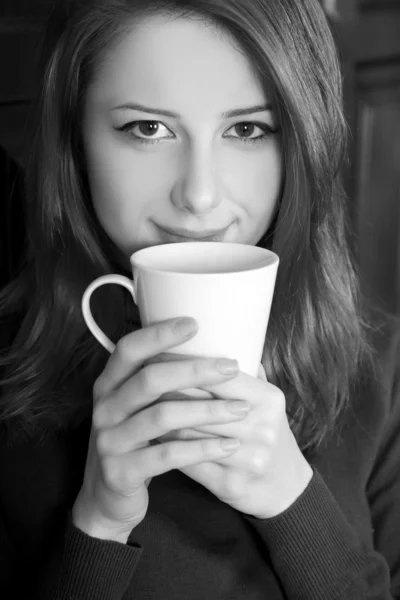 风格的女孩喝咖啡原木门附近。在黑色和 w 的照片 — 图库照片