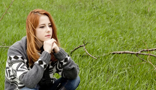 年轻时尚女孩坐在绿色的春天草. — 图库照片