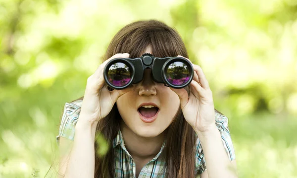 Adolescente chica con binocular en verde hierba — Foto de Stock