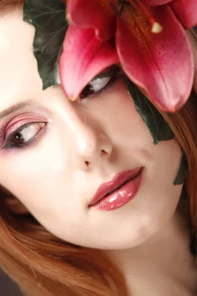 Πορτρέτο του κοκκινομάλλα κοπέλα με το λουλούδι και μακιγιάζ. — Φωτογραφία Αρχείου
