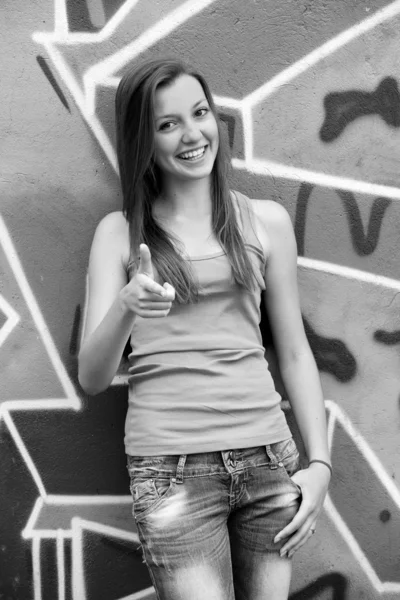 Stil tonåring flicka nära graffiti bakgrund. — Stockfoto