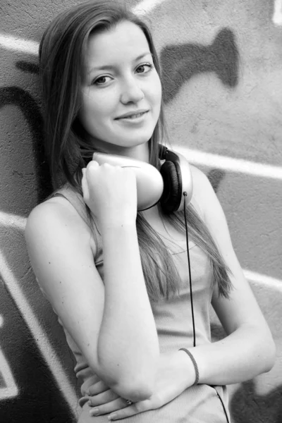 Stil tonåring flicka med solglasögon nära graffiti bakgrund. — Stockfoto