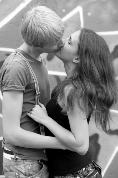 Jeune couple embrasser près de fond de graffiti . — Photo