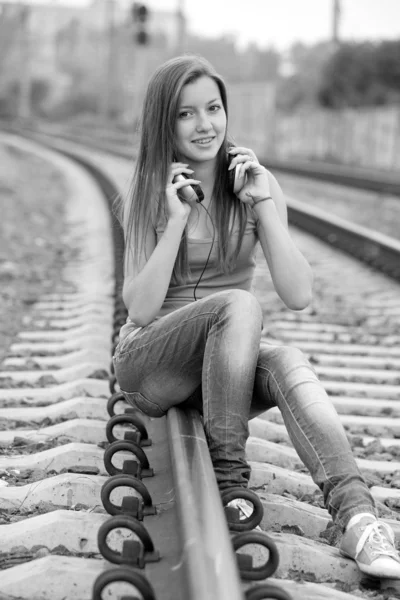 Ragazza adolescente con le cuffie alle ferrovie . — Foto Stock