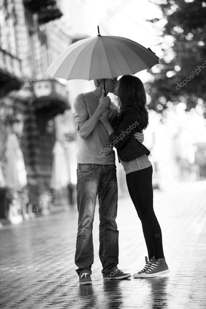 Young couple on the street of the city with umbrella