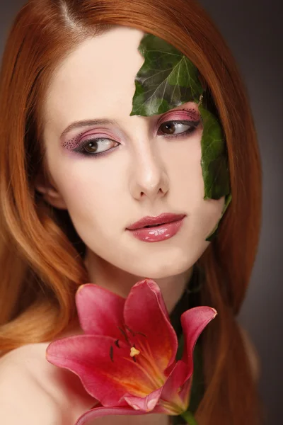 Ritratto di ragazza dai capelli rossi con fiore e trucco . — Foto Stock