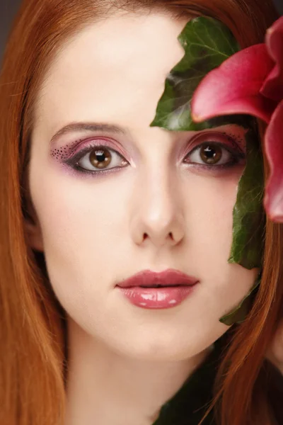 Retrato de niña pelirroja con flor y maquillaje . — Foto de Stock