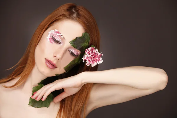 Portrét rusovlasá dívka s květinami a make-up. — Stock fotografie
