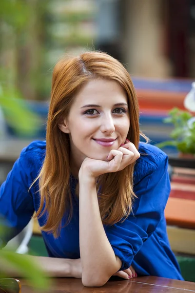 风格红头发的女孩坐在咖啡店的长椅上 — 图库照片