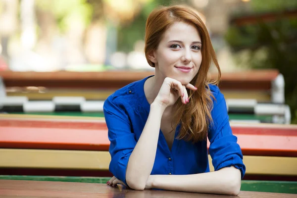 Stijl roodharige meisje zitten op de bank in het cafe — Stockfoto