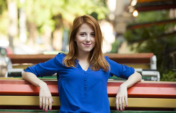 Tarz kızıl saçlı kız kafede bankta oturuyor. — Stok fotoğraf